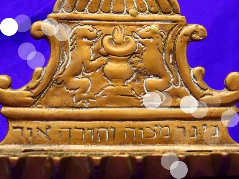 A gold Hanukkah lamp with hebrew script