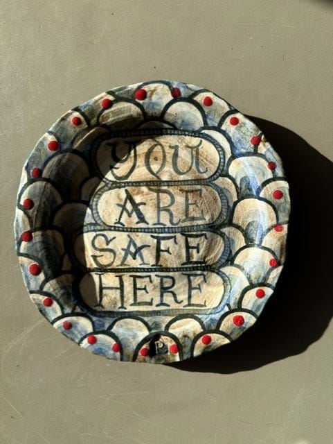 A ceramic plate painted with the words 'You are safe here'