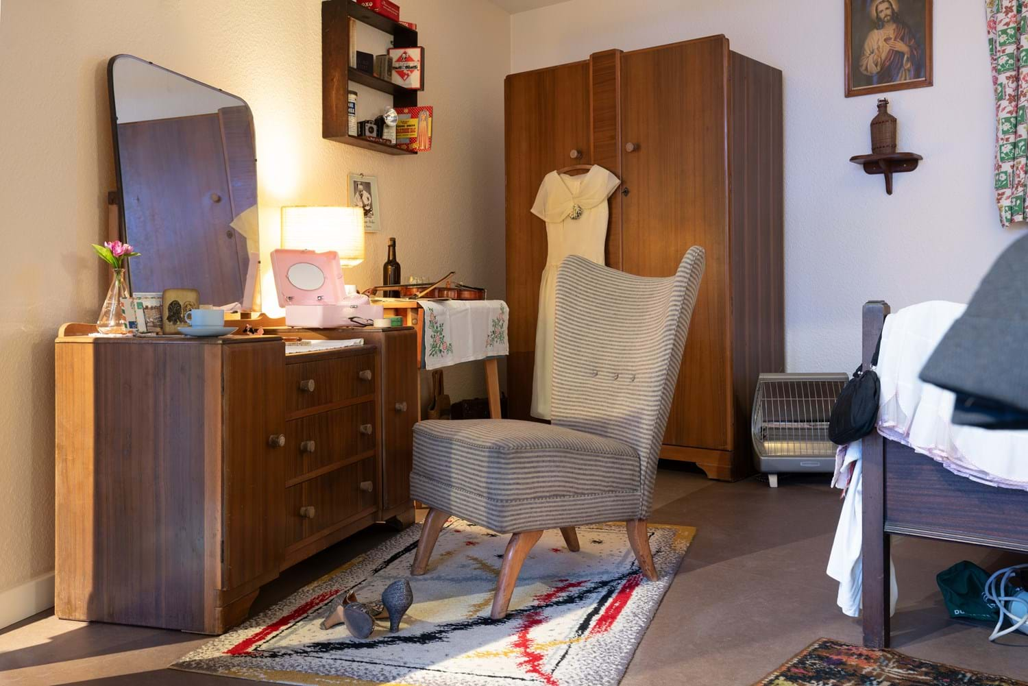 A wide shot of A Room Upstairs in 1956 at Museum of the Home. It is of the bed and vanity table with mirror.