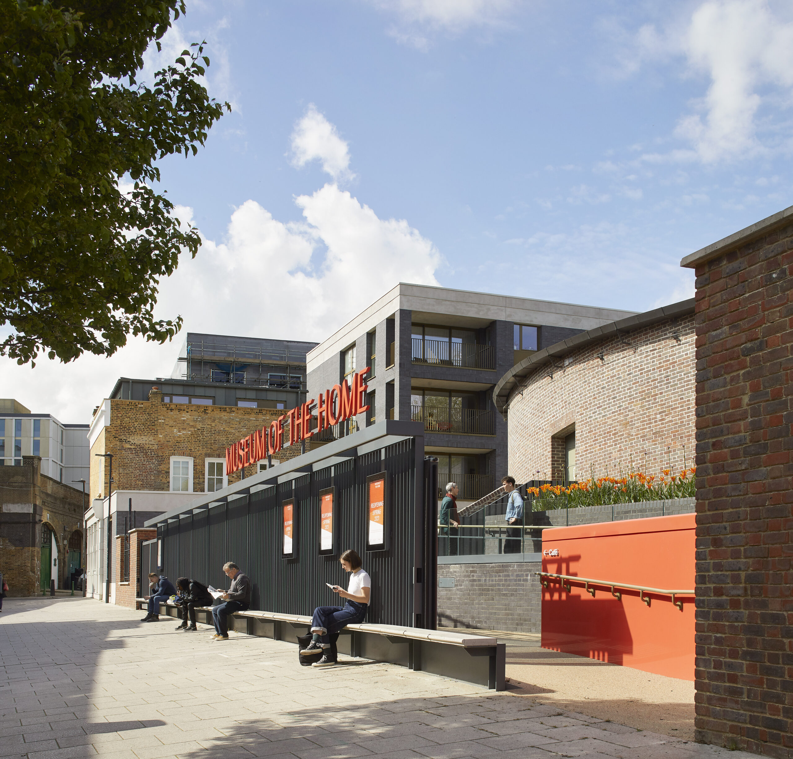 Exterior of the Museum with a gate and orange walls, trees and blue skies