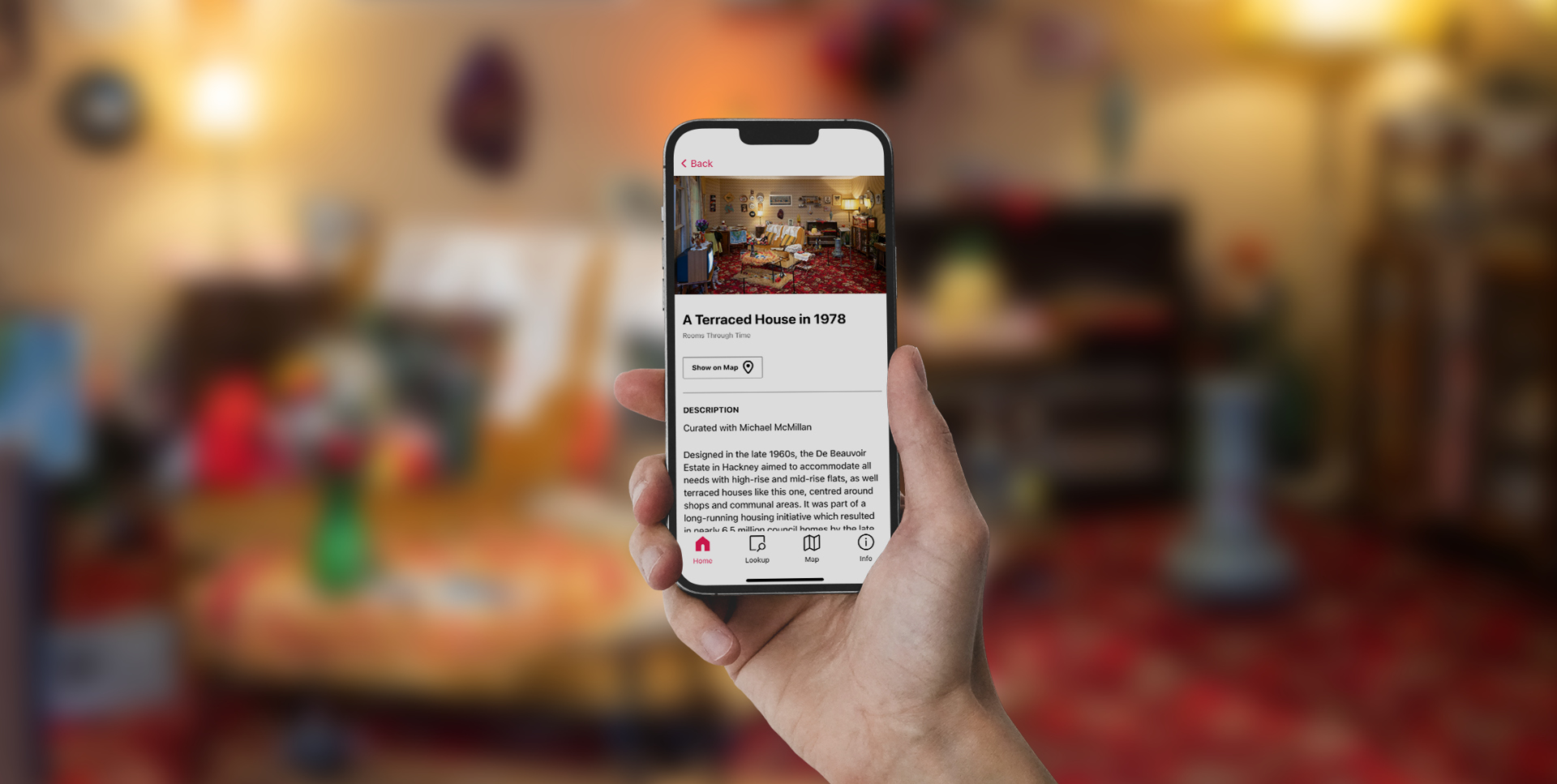 A hand holding up a smartphone displaying information and an image of a terraced house from 1978, with the actual display blurred in the background.