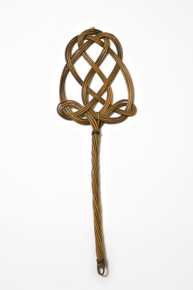 Woven rattan carpet beater with intricate braided pattern and long handle