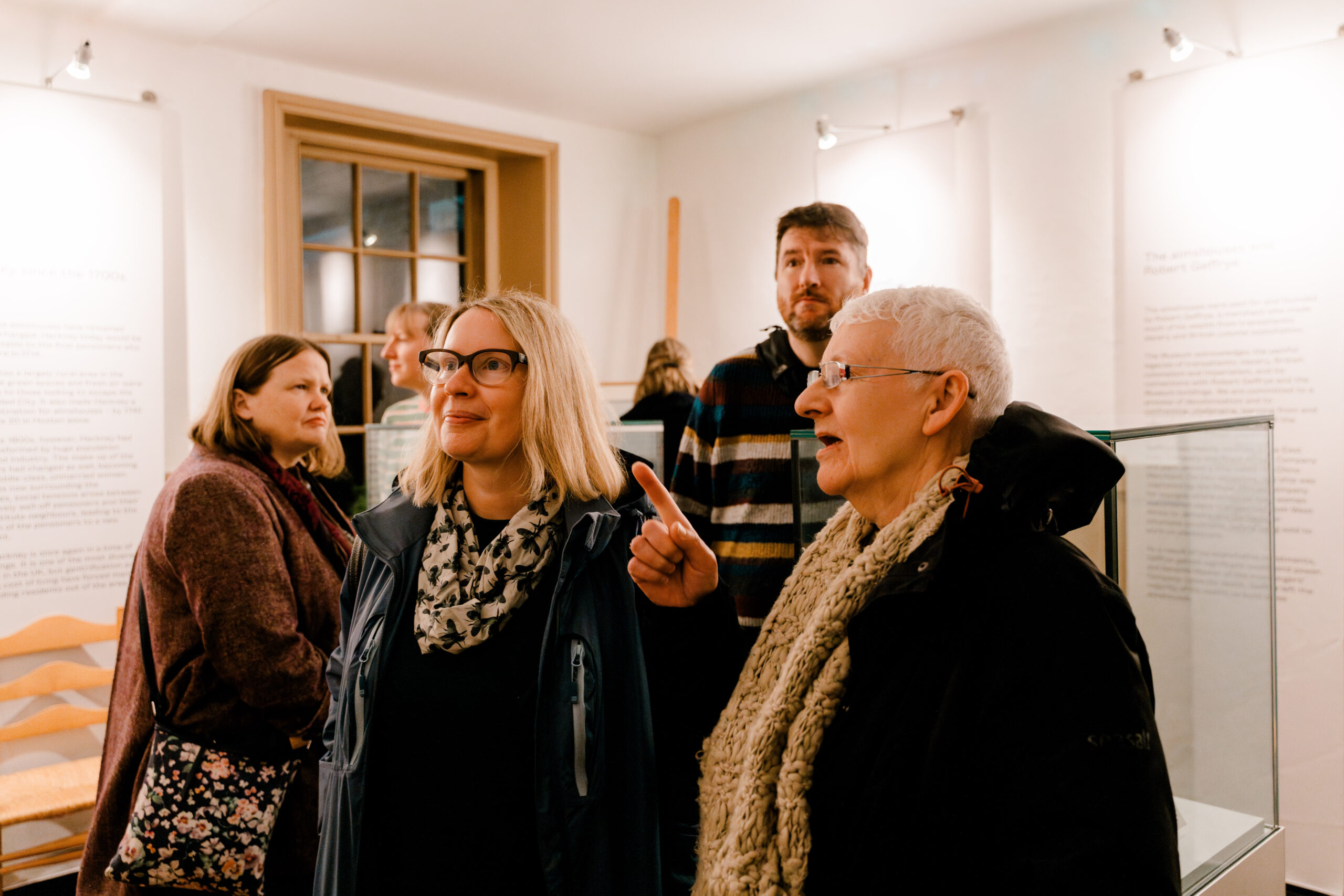 a group of people smiling and looking at a wall in a room