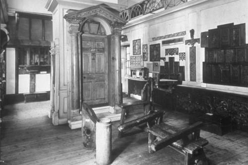 A black and white photo of a room in Museum of the Home with various wooden items displayed