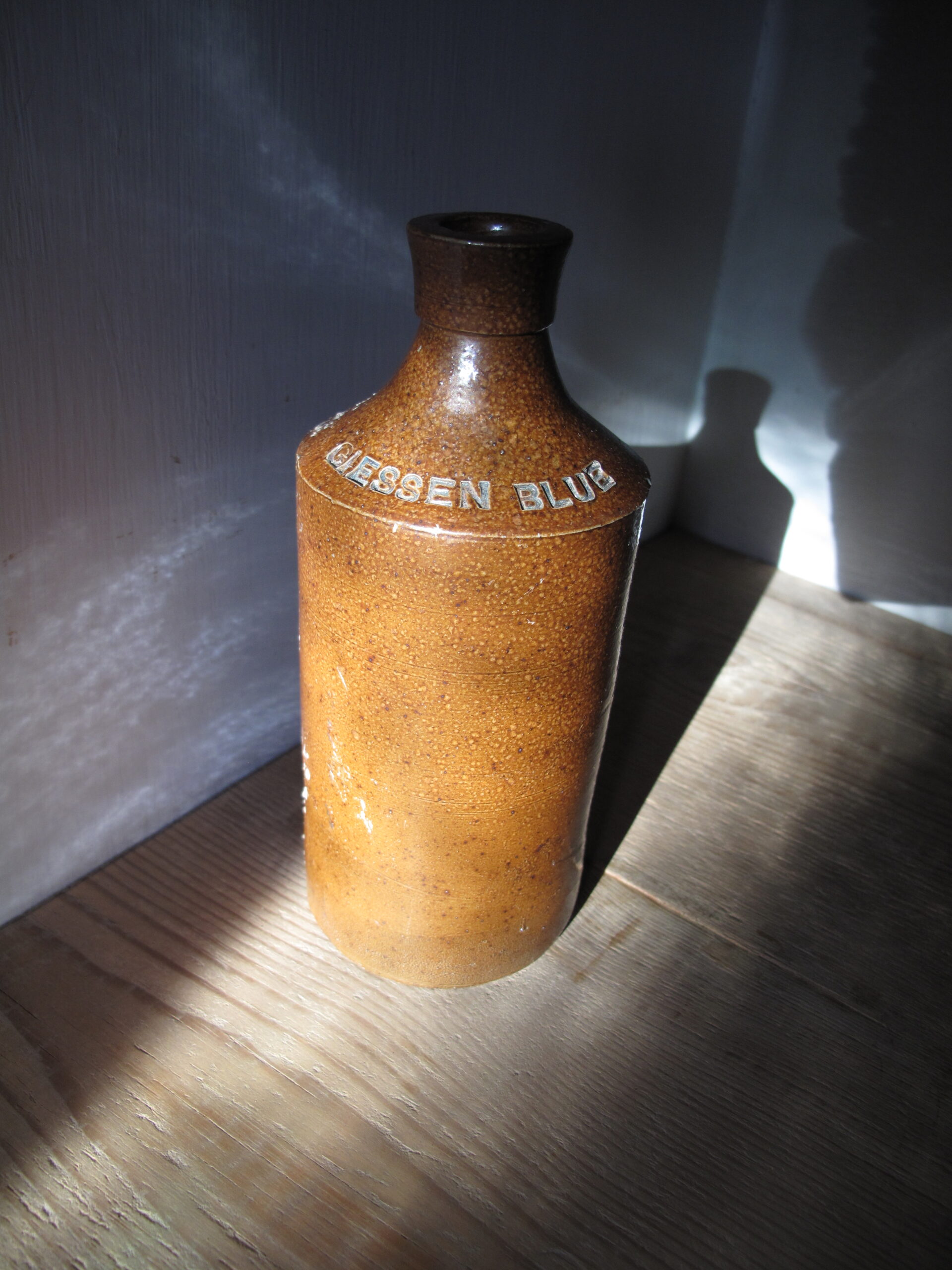 Brown earthenware bottle with 'GISSEN BLUE' embossed text.