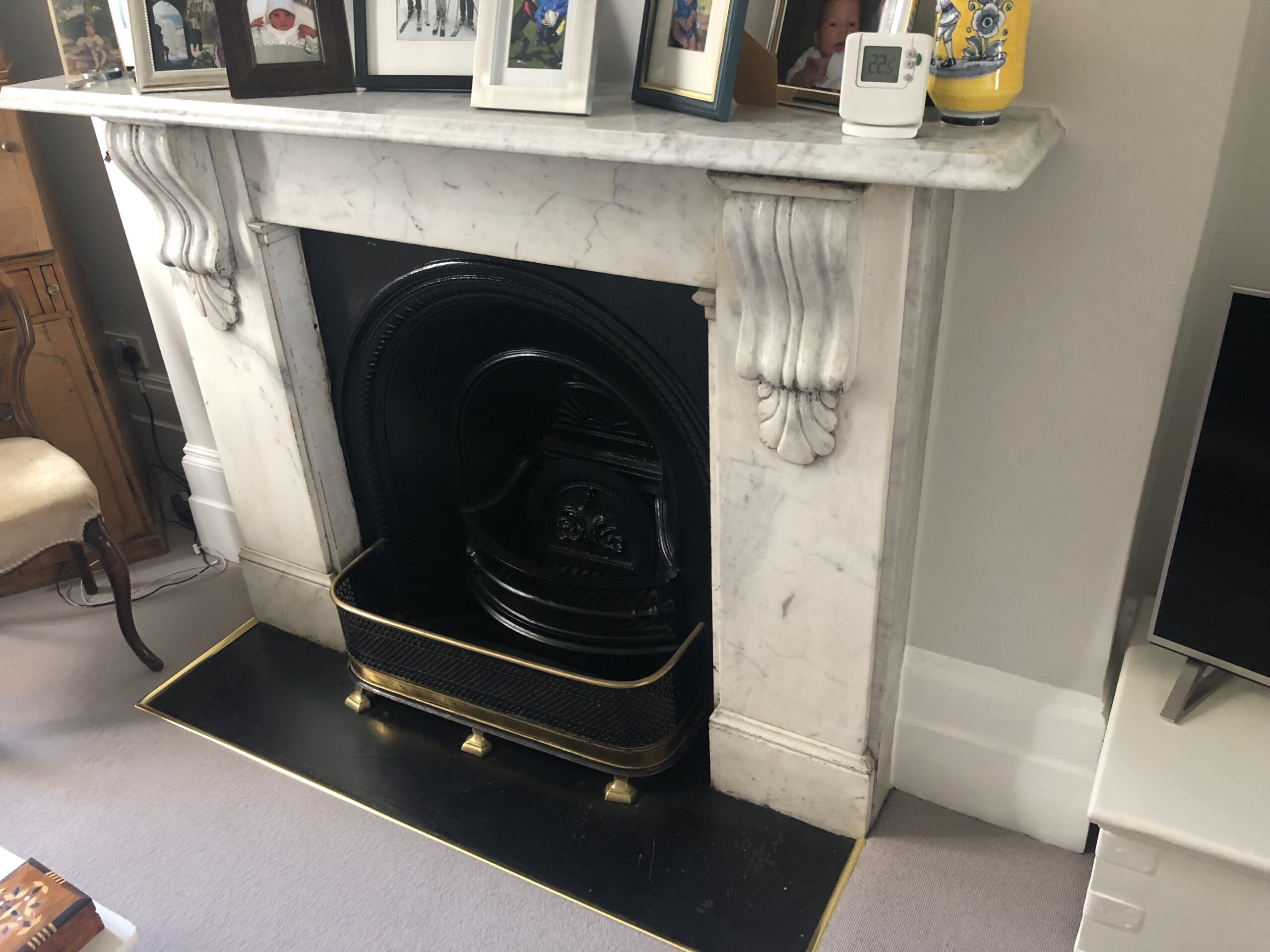 White marble fireplace with carved details and black cast iron insert.
