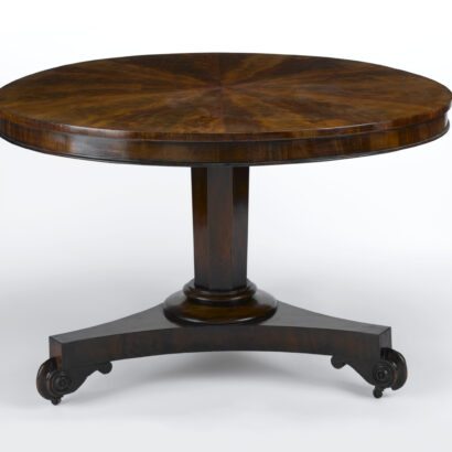 Round wooden table with pedestal base and scrolled feet.