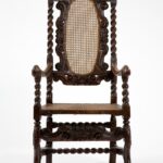 Chair with twisted posts, carved decoration, and cane seat and back.
