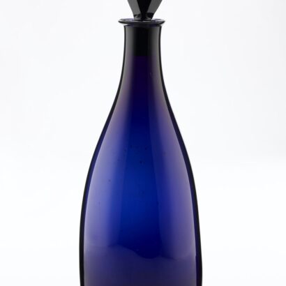 Dark blue tapered glass decanter with pear shaped black stopper.