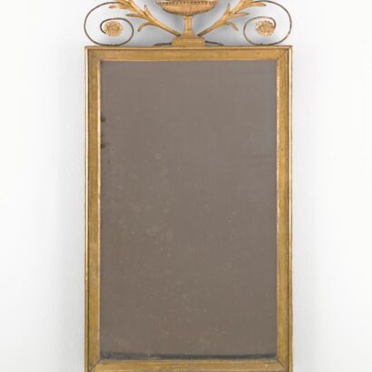 Gilt-framed vertical mirror decoratively surmounted by a vase.