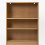 A wooden bookcase with three empty shelves made of light coloured wood.