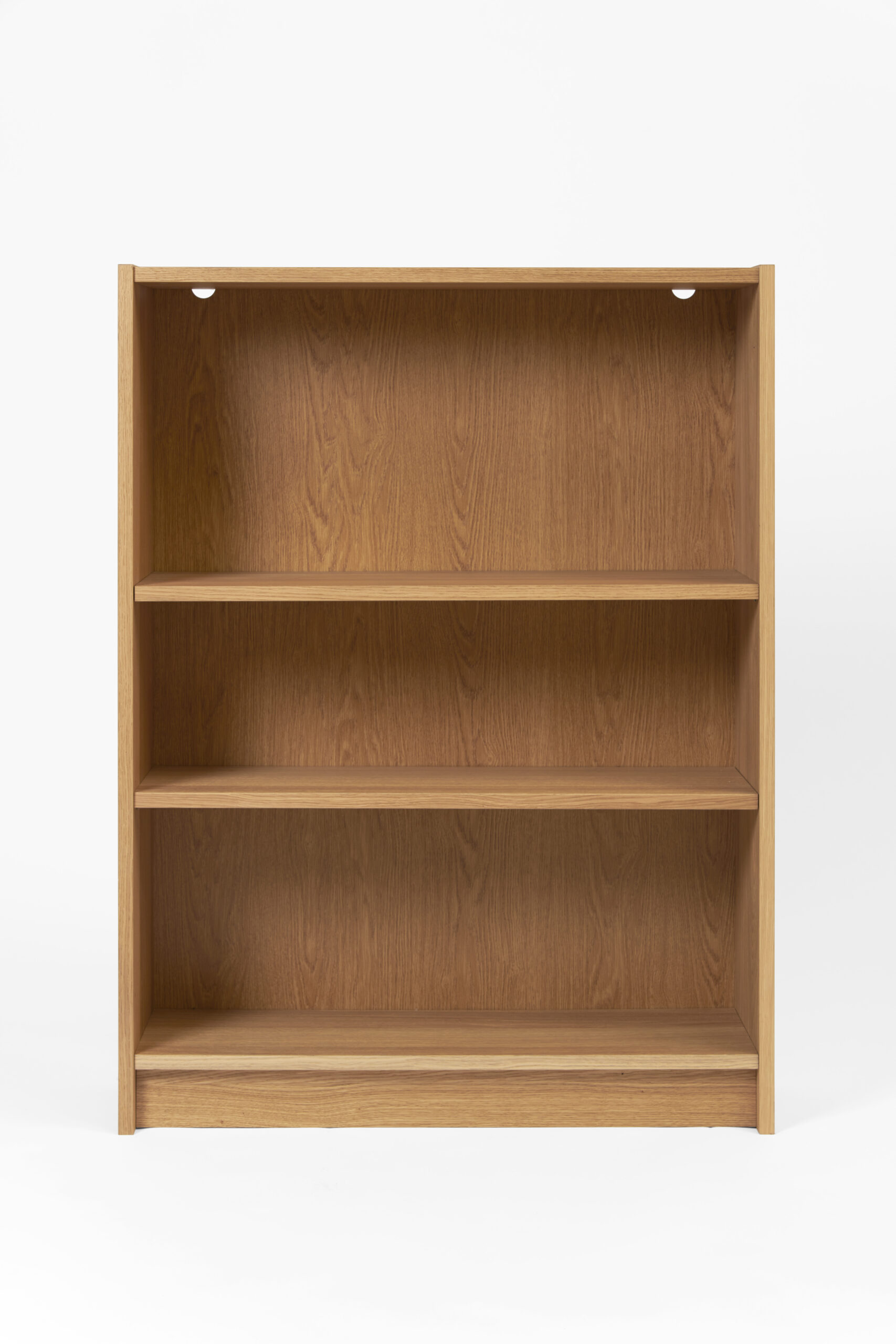 A wooden bookcase with three empty shelves made of light coloured wood.