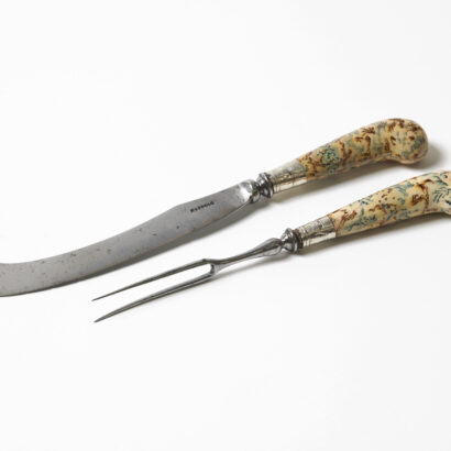 A curved knife and two-pronged fork with decorative, patterned handles.