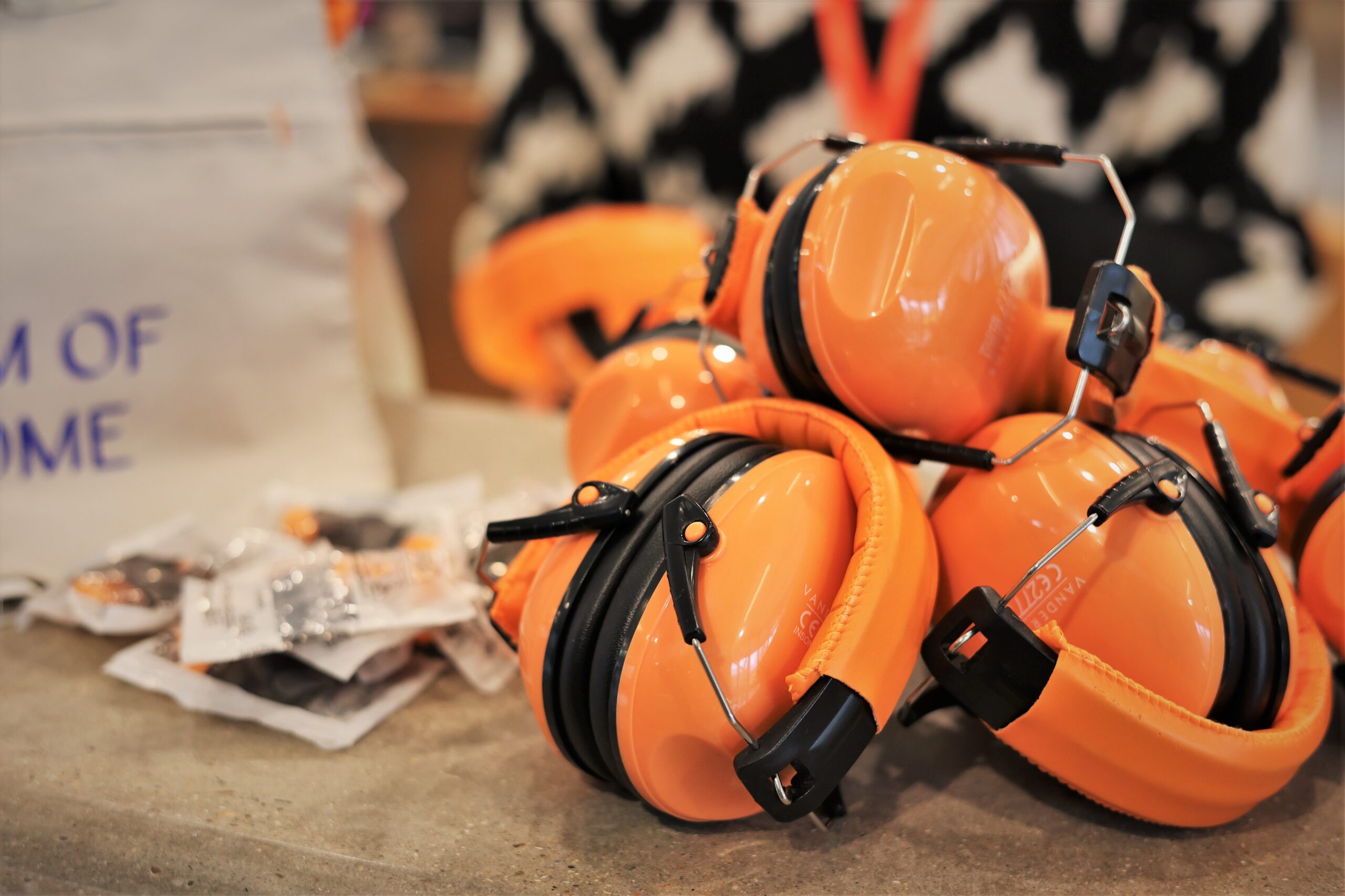 Orange noise cancelling ear covers on an desk