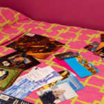 Noughties memorabilia strewn on a bed with hot pink bedding and walls.
