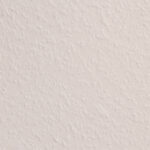 A close-up view of a white textured wall surface with a subtle raised pattern creating visual texture.