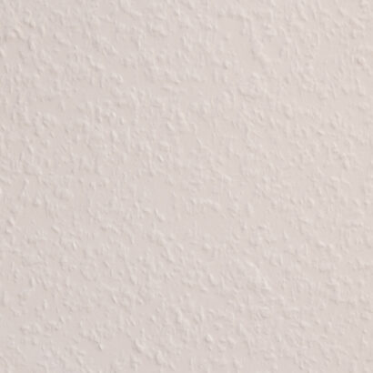 A close-up view of a white textured wall surface with a subtle raised pattern creating visual texture.