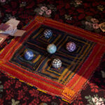 Five colourful balls sit on a geometric textile.