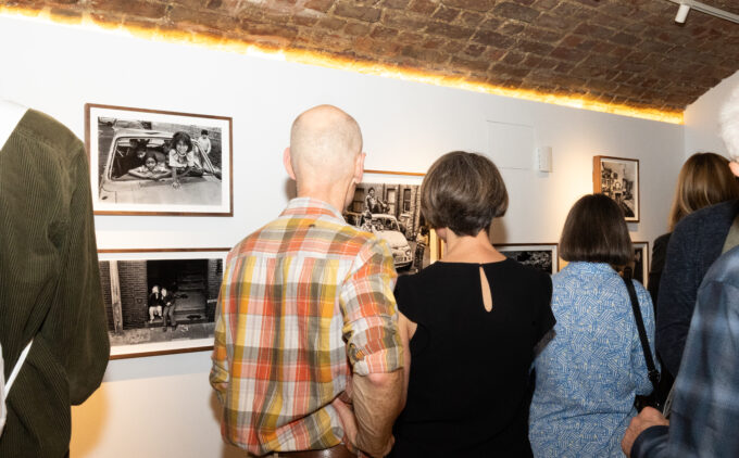 Two people viewing black and white photography at an exhibition.