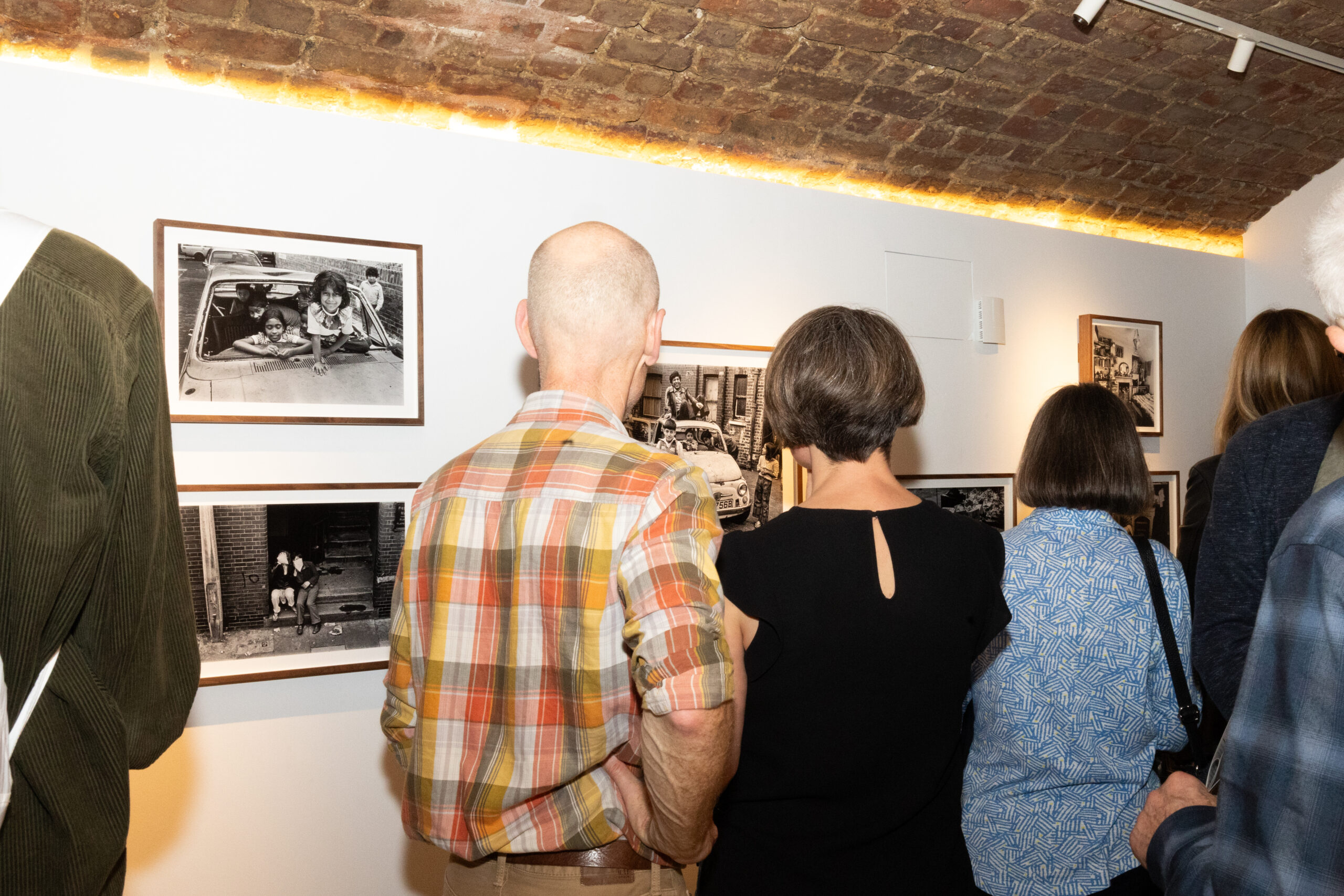 Two people viewing black and white photography at an exhibition.