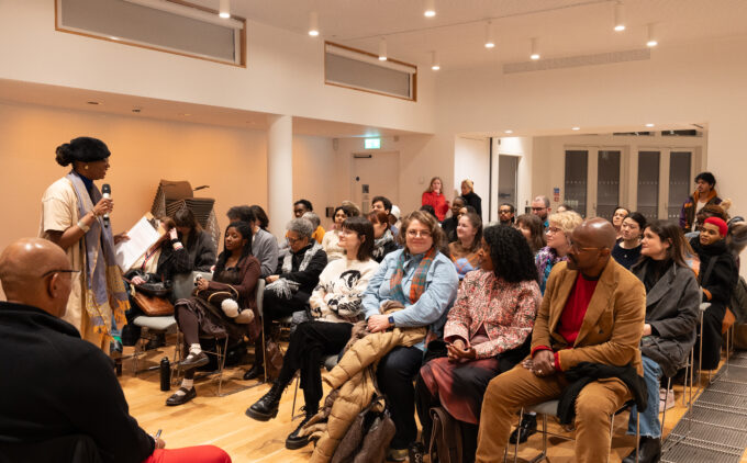 An audience sit listening to a speaker from a panel discussion