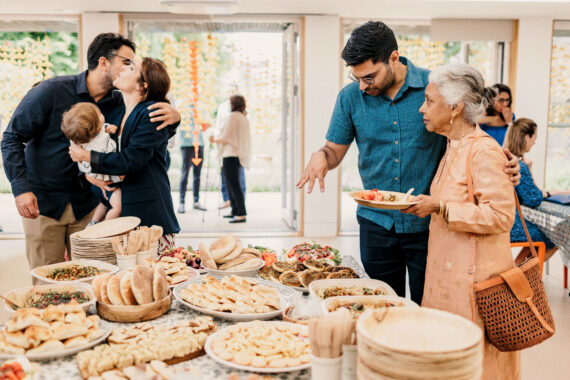 A wedding with a table laid with food and people enjoying themselves