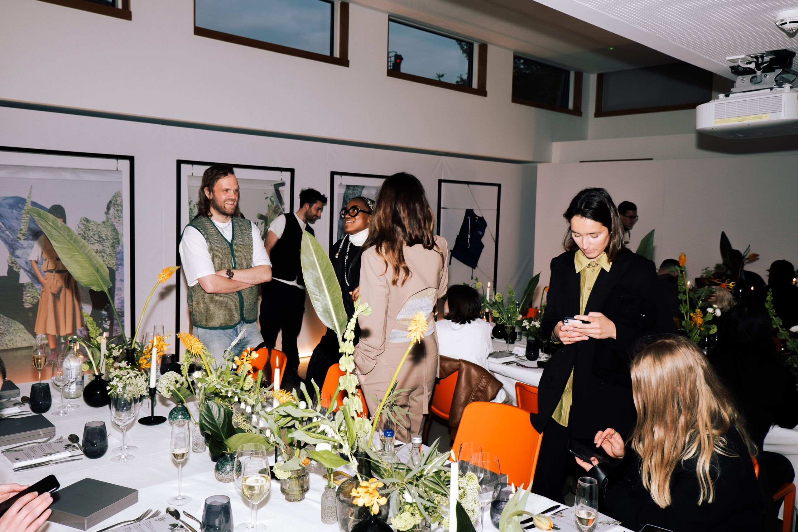 A busy and buzzing indoor event with decorated tables and people chatting