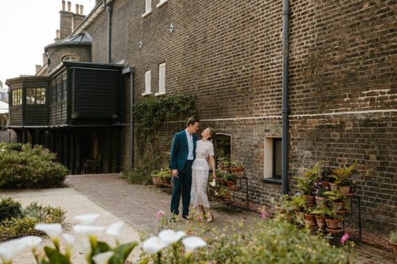 A wedding couple walk down the Gardens at Museum of the Home smiling together