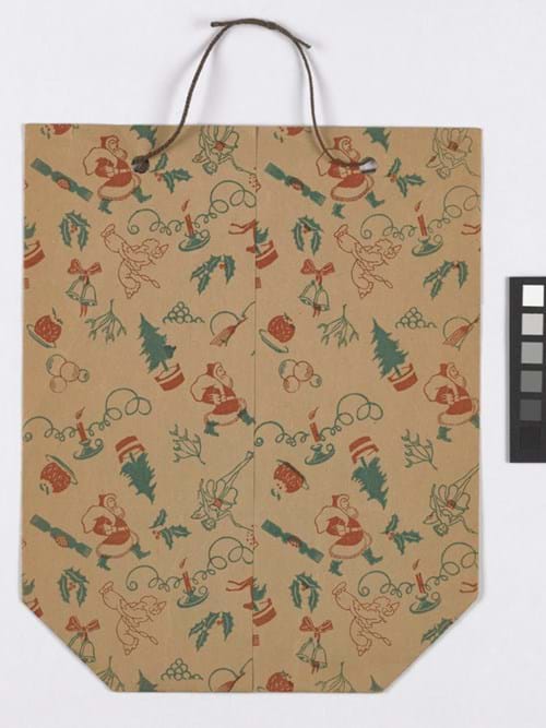 Christmas gift bag with green and red festive holiday pattern and brown handles