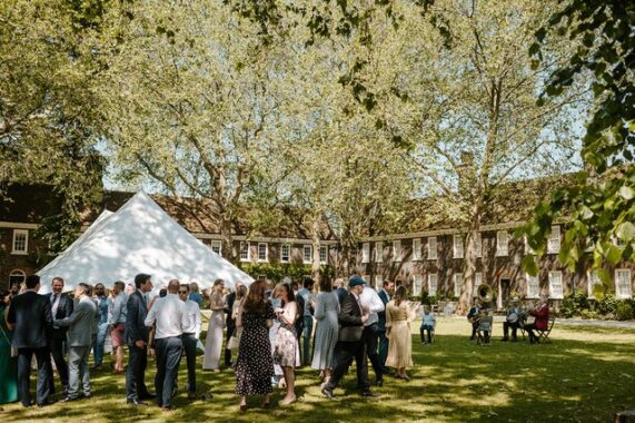 A wedding reception on a green lawn and a white canape
