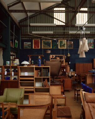 Vintage furniture with mid-century modern pieces, exposed beam ceiling, and framed artwork