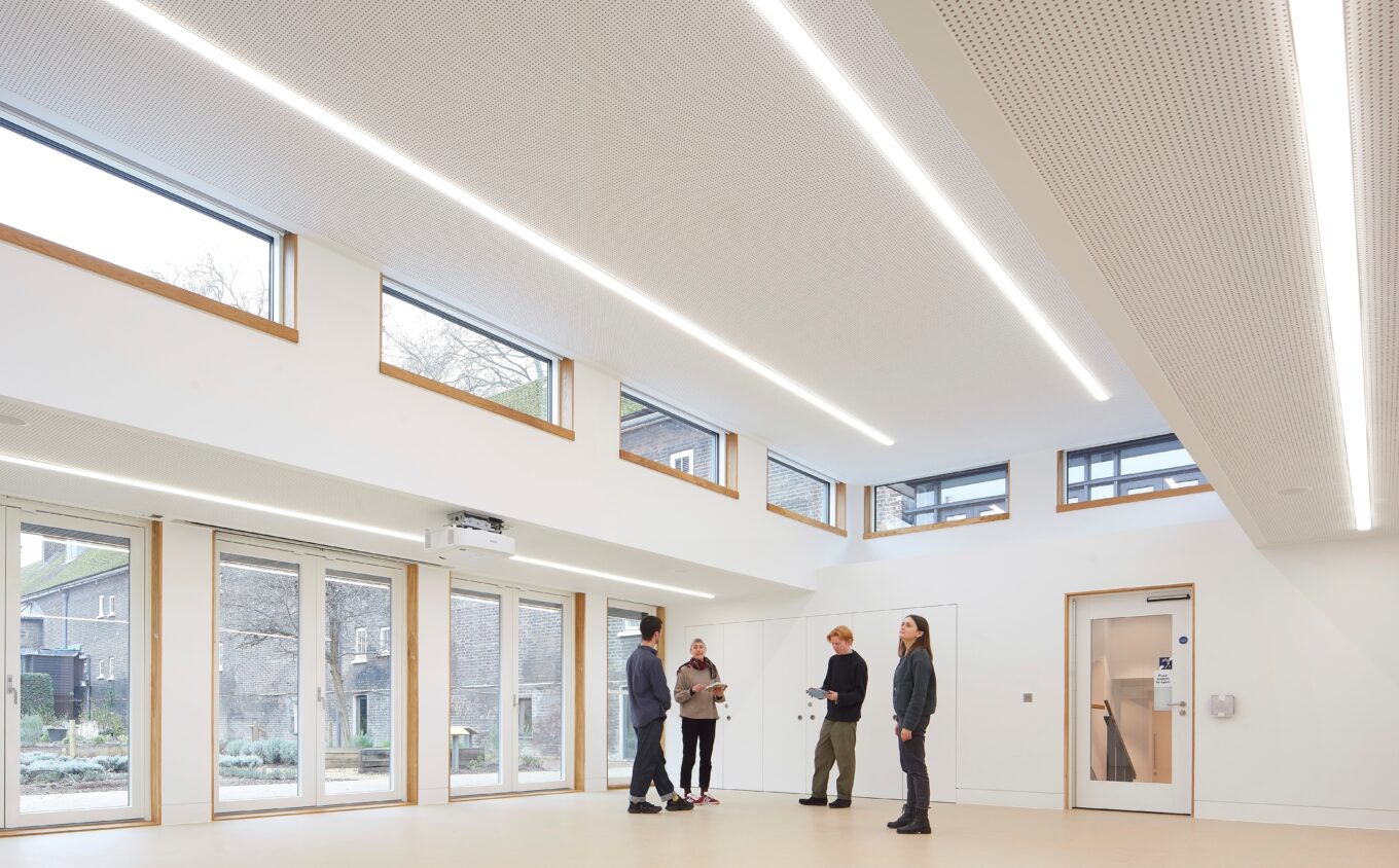 A large white studio space with glass doors into a garden