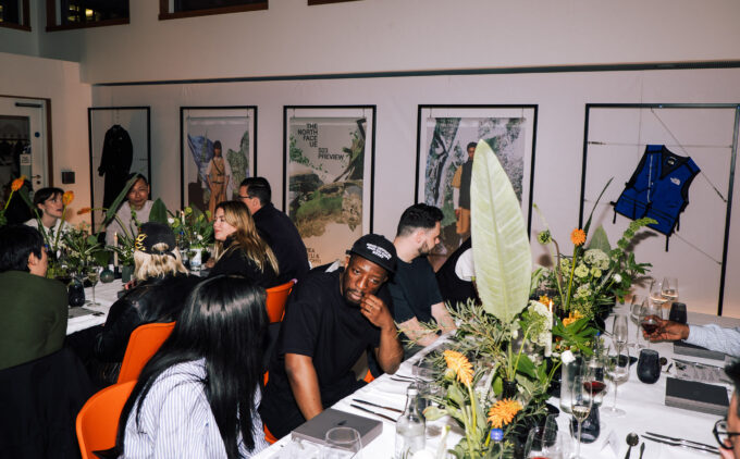 A group of people sitting at tables decorated with flowers and plants in the Studio