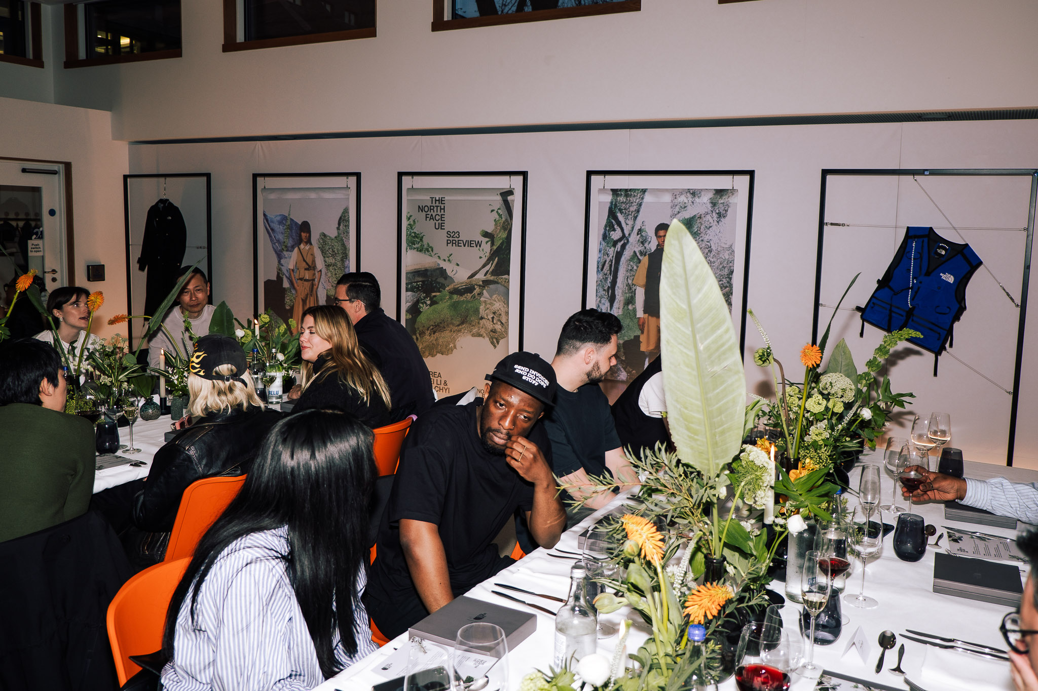 A group of people sitting at tables decorated with flowers and plants in the Studio