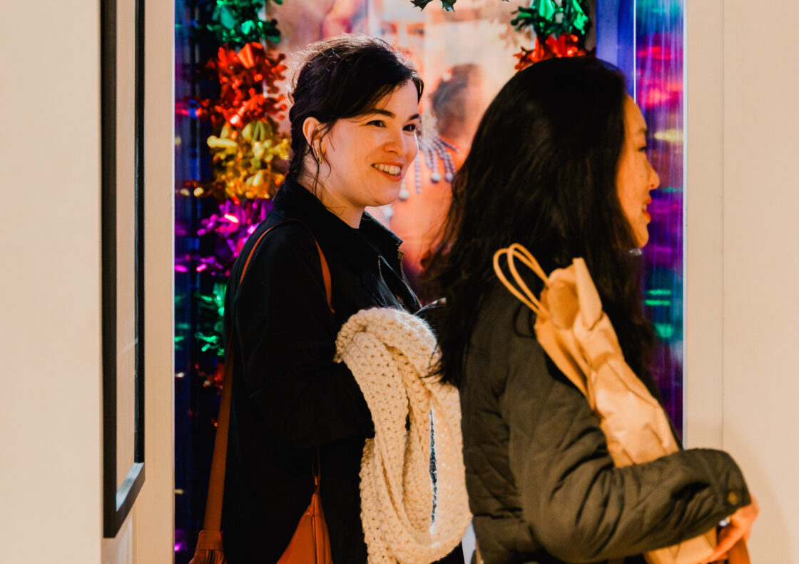 Two people smiling in a room with christmas decorations