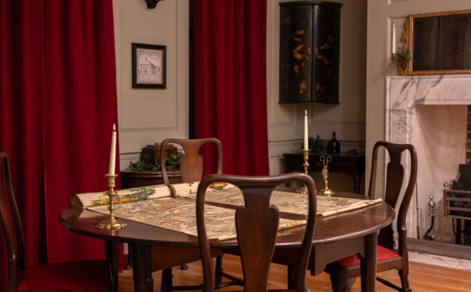 A parlour dressed with various winter items including candles and silk on the table.