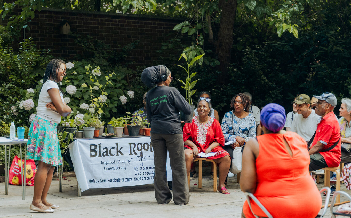 a group of people in colourful outfits gathered around in a garden