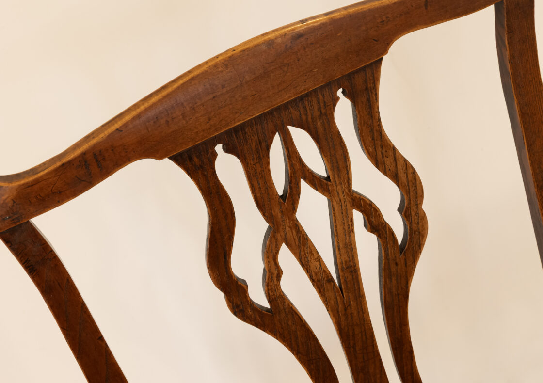 A close up photograph of the splats and spindles of a wooden chair.