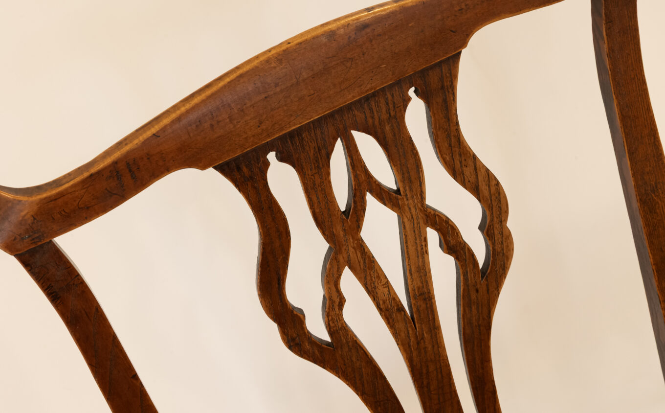 A close up photograph of the splats and spindles of a wooden chair.