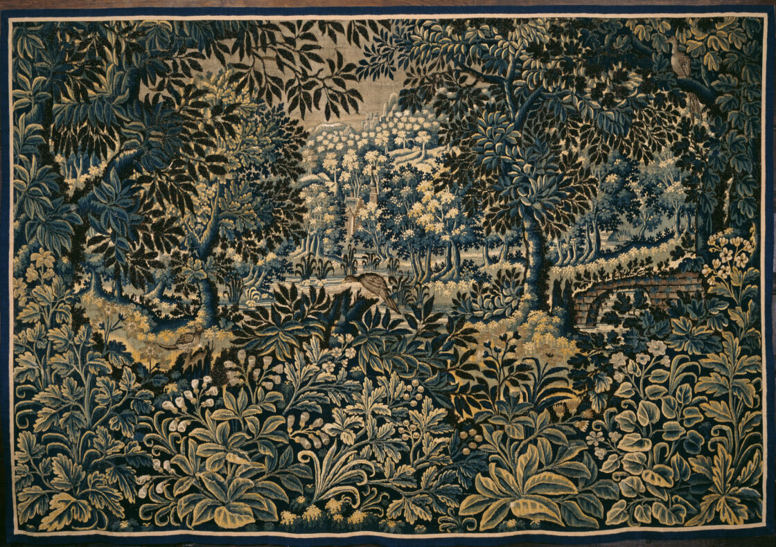 An embroidered tapestry depicting a landscape of detailed plants and foliage in hues of gold, cream and teal.