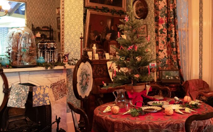 A table with small Christmas tree, dolls, and baubles.
