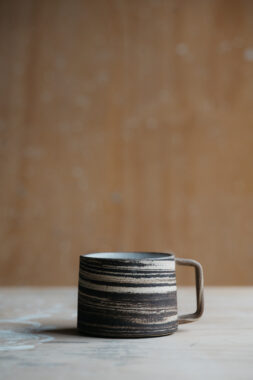 A ceramic mug with thin handle and neutral toned design