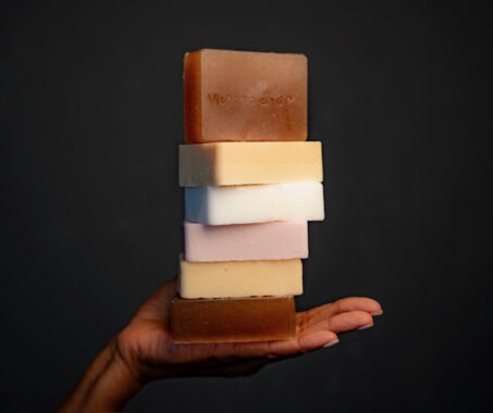 A hand holding a selection of natural soaps